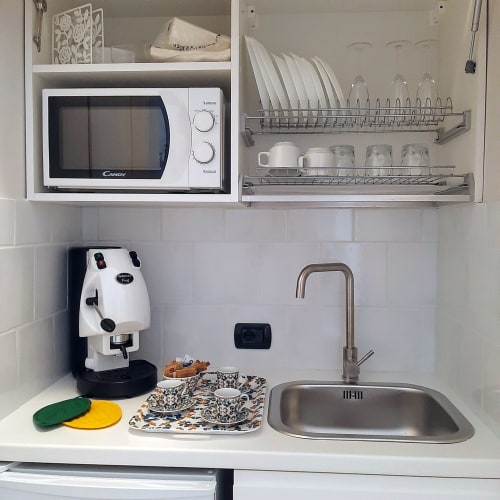 Piccolo angolo cottura al My Comfort Suite Naples con microonde, scolapiatti, macchina da caffè, lavello e elettrodomestici