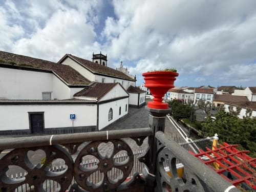 Vista da histórica vila portuguesa da varanda da Golden Mermaid Villa com igreja branca, estátua vermelha e arquitetura tradicional