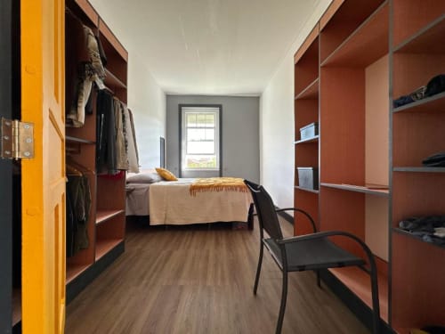 Quarto moderno na Golden Mermaid Villa com guarda-roupas embutidos em madeira, cama com vista para o lago e piso de madeira de lei.