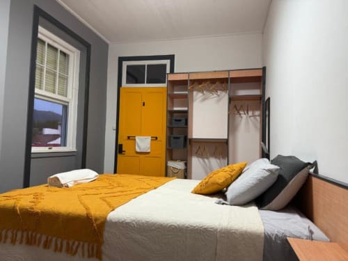 Double bedroom at Golden Mermaid Villa with garden view, featuring yellow bedding and wooden wardrobe