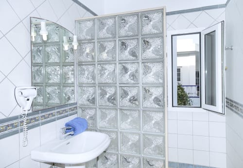 Modern bathroom with textured glass shower enclosure and white tiles at Villas del Mar, Puerto Calero