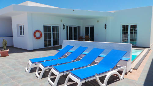 Blue loungers by private pool at Villas del Mar villa in Puerto Calero, Las Palmas