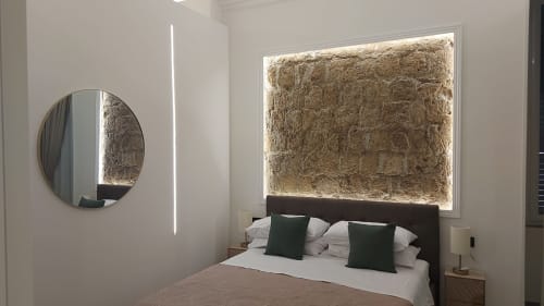 Camera moderna a Pignasecca Domus a Napoli con testata rivestita, specchio rotondo e cuscini accent verde