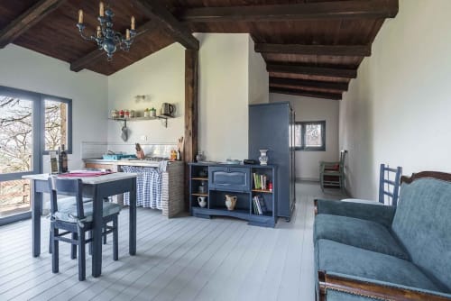 Zona living e cucina open space dell'appartamento Donkeys & Roses a Viterbo con cabinetry blu, tavolo da pranzo e sedute rivestite