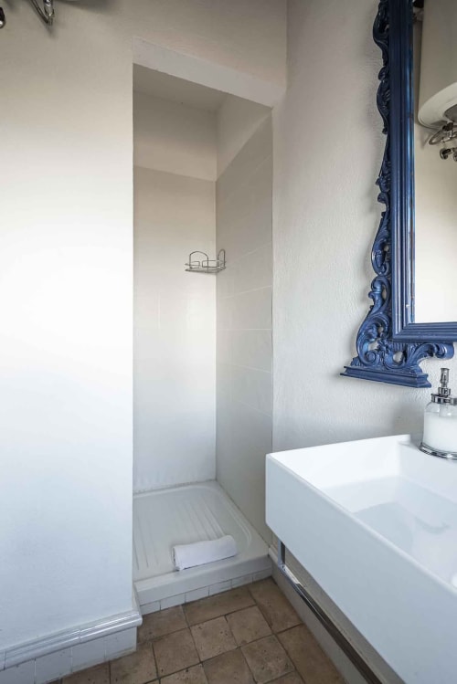 Bagno moderno nell'appartamento Donkeys & Roses a Viterbo con lavabo bianco, specchio decorativo blu e ampia zona doccia