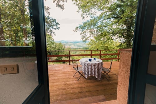 Terrazza in legno con tavolo da pranzo vista campagna di Viterbo all'appartamento Donkeys & Roses