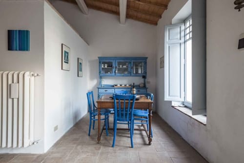 Sedie da pranzo blu al tavolo in legno nella luminosa cucina dell'appartamento Donkeys & Roses a Viterbo, Italia