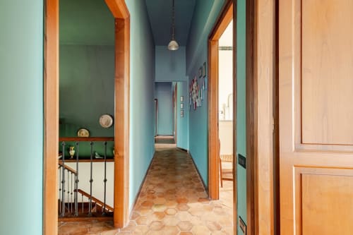 Corridoio turchese con pavimenti in cotto e porte in legno presso l'appartamento Donkeys & Roses a Viterbo