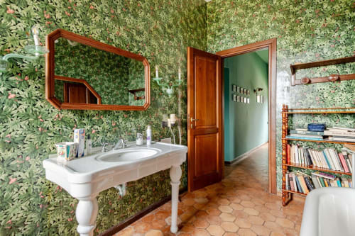 Bagno botanico presso la struttura Donkeys & Roses a Viterbo con carta da parati floreale verde, lavabo vintage su piedistallo e legno
