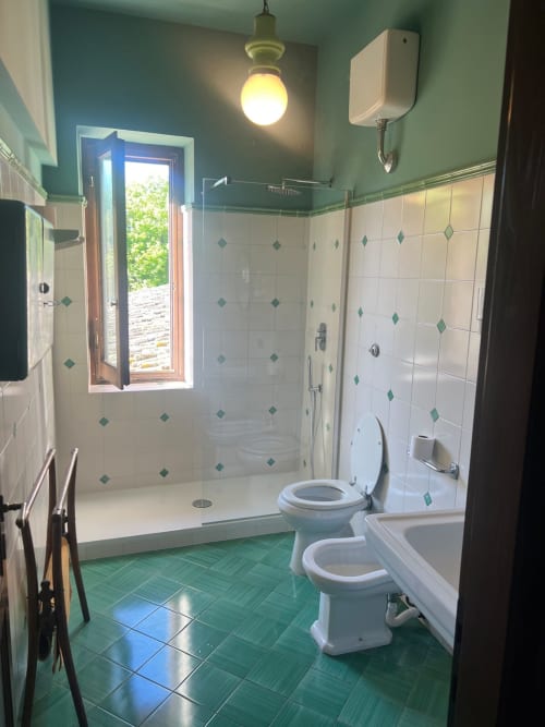 Bagno moderno con doccia walk-in, doppi servizi, piastrelle verdi e luce naturale presso l'agriturismo Donkeys & Roses a Viterbo.