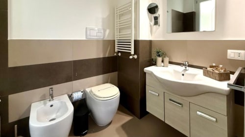 Moderno bagno dell'appartamento a Palermo con doppio lavabo, wc, bidet e piastrelle contemporanee con accesso alla vista mare