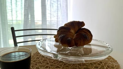Cornetti e caffè su un tavolo con vista mare nell'appartamento di Palermo