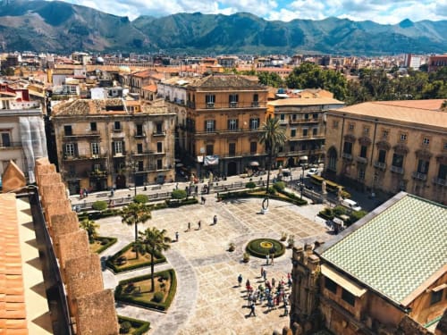Vista aerea della storica piazza Quattro Canti di Palermo con architettura barocca e sfondo montuoso dal balcone dell'appartamento