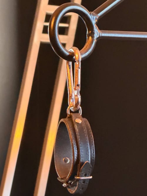 Vintage leather pulley with metal ring on wooden beam at La Maison Defendue, Tessy-Bocage