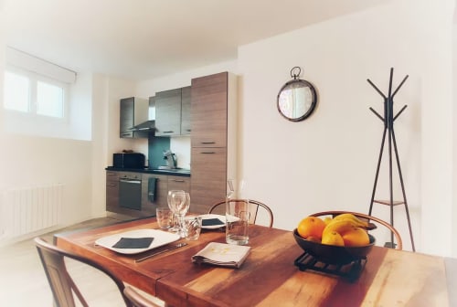 Modern kitchenette and dining area at La Maison Defendue, Tessy-Bocage with wooden table and contemporary décor