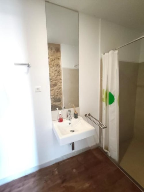 Banheiro moderno com pia branca, espelho e cortina de banho verde na villa SM Stays Collection em Guarda, Portugal