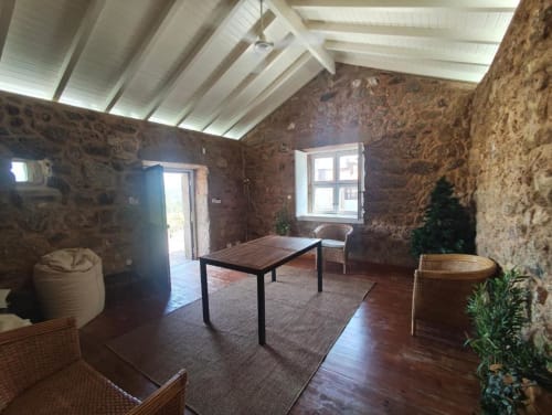 Sala de estar de moradia rústica em Guarda com mesa de jantar em madeira, teto moderno e vistas para o jardim