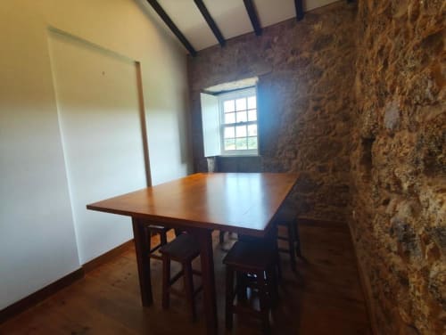 Sala de jantar rústica com mesa de madeira, paredes de pedra e vista para o jardim na villa SM Stays Collection em Guarda