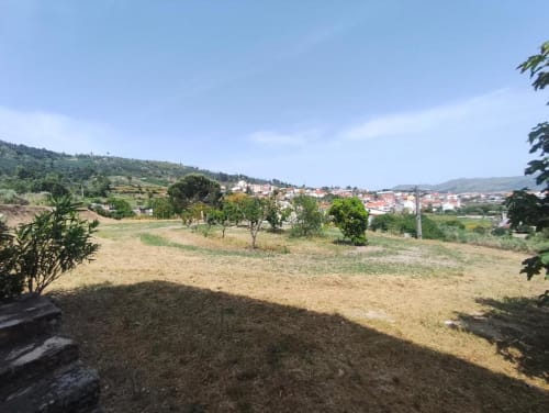 Vista do jardim da villa em Guarda, Portugal com paisagem em socalcos e edifícios da cidade ao fundo