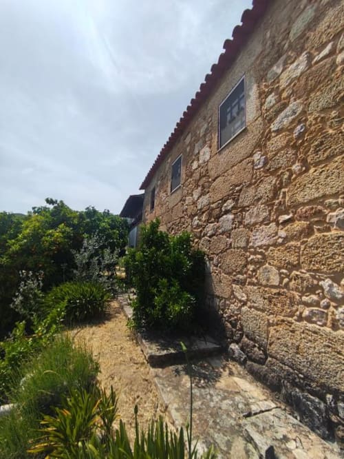 Vila de pedra em Guarda com vista para o jardim, arquitetura rústica e vegetação exuberante