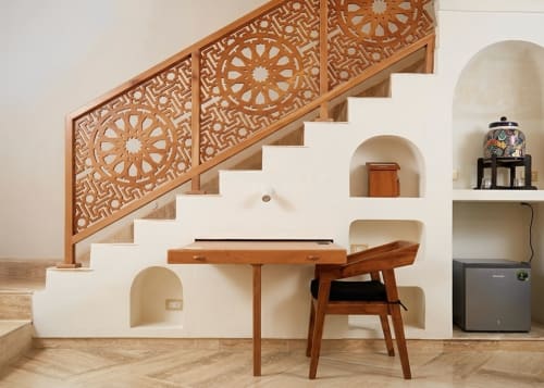 Habitación de boutique hotel en Mérida con barandilla de escalera de madera ornamentada, escritorio de trabajo y estantería de nicho arqueado