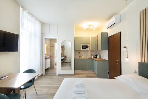 Modernes Studio in den Magnolia Apartments Mailand mit Kochnische, Bett, Arbeitsbereich und eigenem Badezimmer