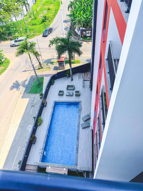 Aerial view of Cozy Apartments Ghana pool and patio in Accra with street and parked cars