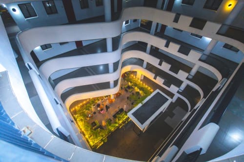 Overhead view of modern apartment building courtyard with illuminated green courtyard space at Cozy Apartments Ghana, Accra