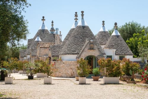Bed and breakfast Trulli Boccadoro con caratteristici edifici trullo a tetto conico, facciate in pietra e corte giardino