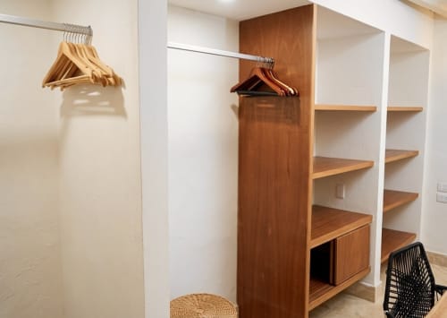 Vestidor moderno en Villa Merida Boutique Hotel con barra de madera, estanterías y armario de almacenamiento en Mérida, México