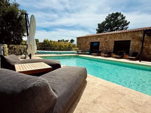 Piscine turquoise avec transats aux Villas d'A Storia, resort de luxe à Porto-Vecchio avec villa en pierre.