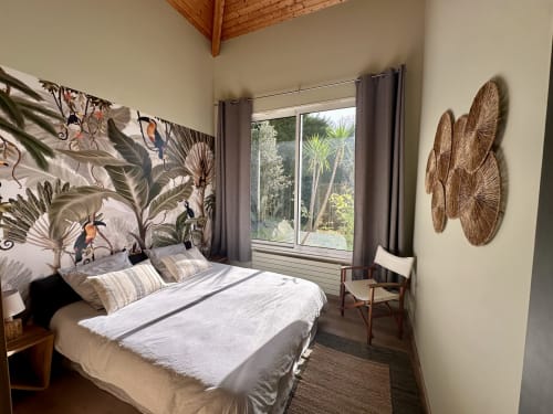 Chambre lumineuse à la Villa Ongizatea à Urrugne avec art mural tropical, décoration tissée et vue sur le jardin par de grandes fenêtres
