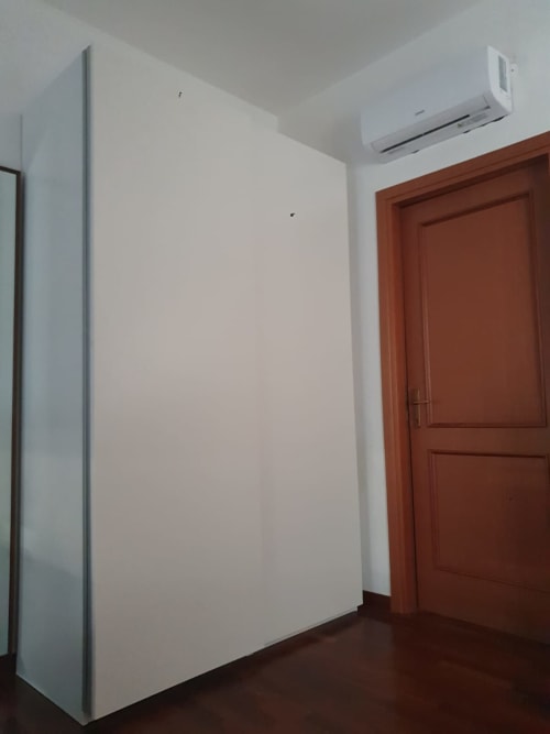 Moderno appartamento a Roma con pareti bianche, porta in legno, aria condizionata e pavimentazione scura