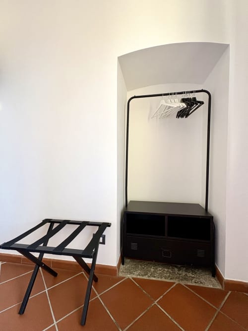 Black luggage rack and clothing rack in Camera 3 at La Dolce Casa B&B, Cremia, Italy