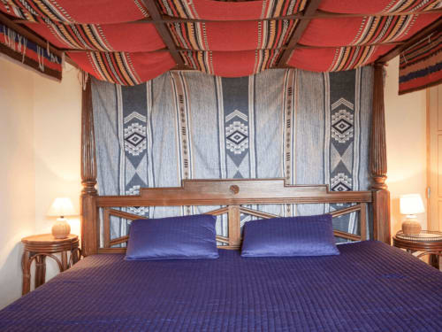 Four-poster bed with blue bedding in a cozy bedroom at Le Lama Zébré B&B in Penmarch, France