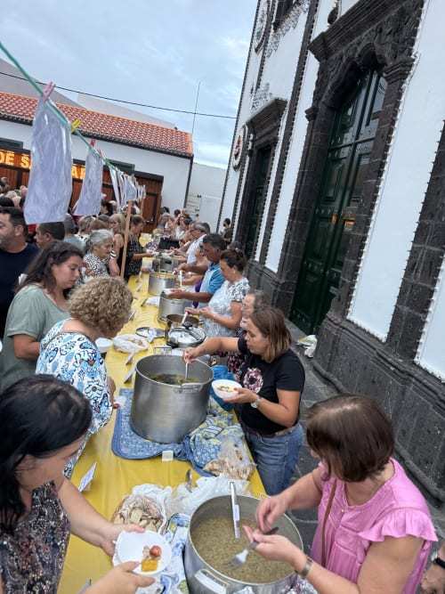 Community feast at Golden Mermaid Villa, guests serving traditional Portuguese food at outdoor table