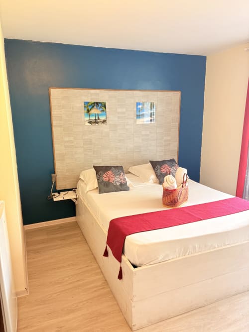 Chambre double à l'Hôtel le soleil couchant à St Pierre, mur d'accent bleu et vues sur le jardin