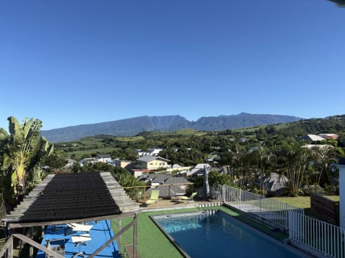 Piscine et jardin de l'Hôtel le Soleil Couchant avec vue sur les montagnes à Saint-Pierre, La Réunion