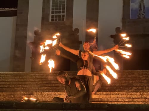 Fire performers juggle flaming torches on steps at Golden Mermaid Villa, a Portuguese bed and breakfast entertainment venue