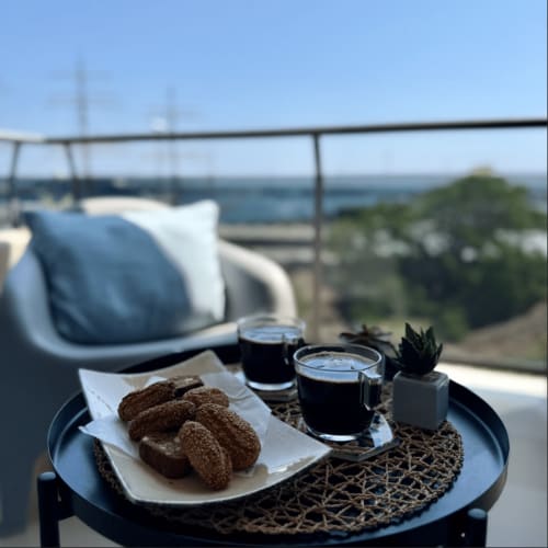 Vista dalla terrazza sul tetto a Palermo con caffè, dolci e paesaggio marino