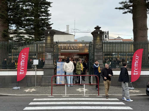Entrance to Golden Mermaid Villa with red Tremor flags, decorative gates, and guests arriving at the Portuguese property