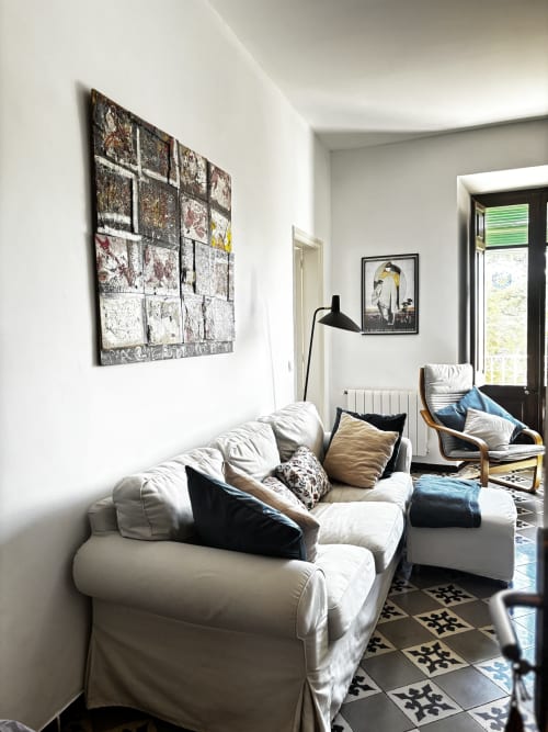 Bright living room at Mas Ribas Hotel in Palamos with white sofa, artwork, wooden chair, and garden view through glass door