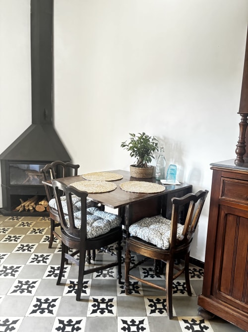 Dining area in Albergínia room at Mas Ribas Hotel, Palamós with wooden table, chairs, fireplace and patterned tiles