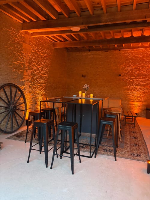 Salle à manger rustique au Domaine Du Grand Fort avec briques apparentes, poutres en bois, comptoir de bar et éclairage ambiant chaleureux