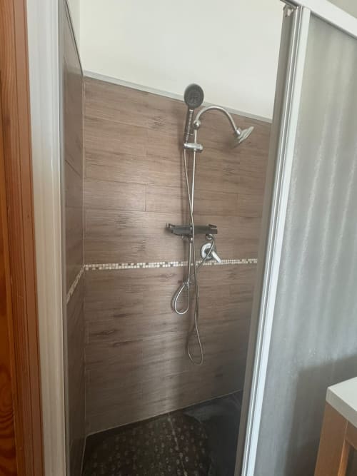 Baño moderno con azulejos tipo madera en tonos marrones y ducha de lluvia en Residenza Leonardo, Falconara Marittima
