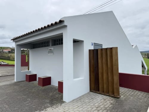 Entrada moderna e branca da Golden Mermaid Villa B&B em Portugal com portões de madeira e detalhes em vermelho