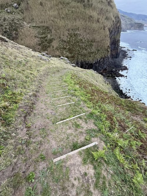 Falésias costeiras com escadas de pedra descendo até águas turquesas na Villa Golden Mermaid, Portugal