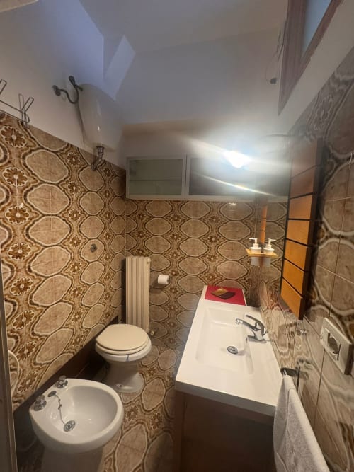 Baño moderno con azulejos estampados, bidé, inodoro y lavabo en B&B Residenza Leonardo, Falconara Marittima