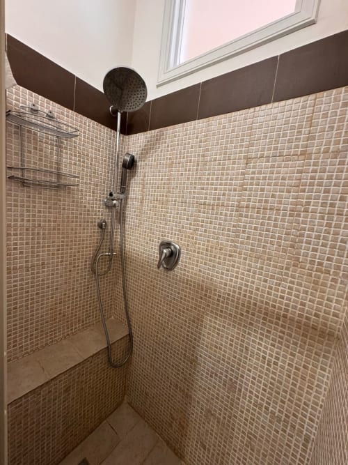 Moderno baño con azulejos mosaico crema, ducha tipo lluvia y herrajes oscuros en B&B Residenza Leonardo, Falconara