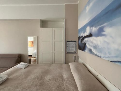 Camera moderna al B&B Leonardo di Falconara Marittima con letti gemelli, quadri con vedute montane, armadio e vista panoramica sulla montagna